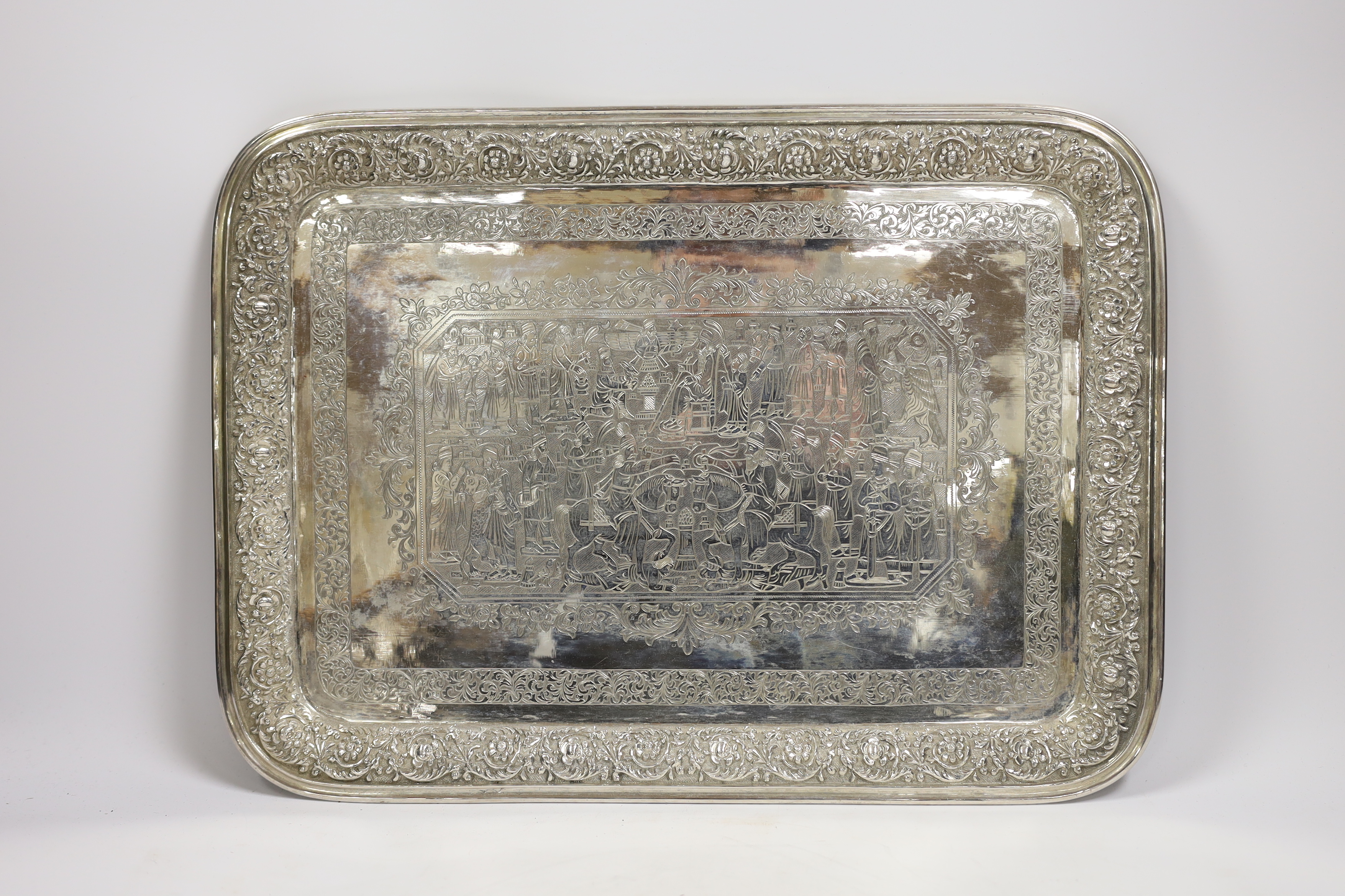 A Persian? engraved white metal tea tray, with embossed foliate border, 42cm, 46.4oz.